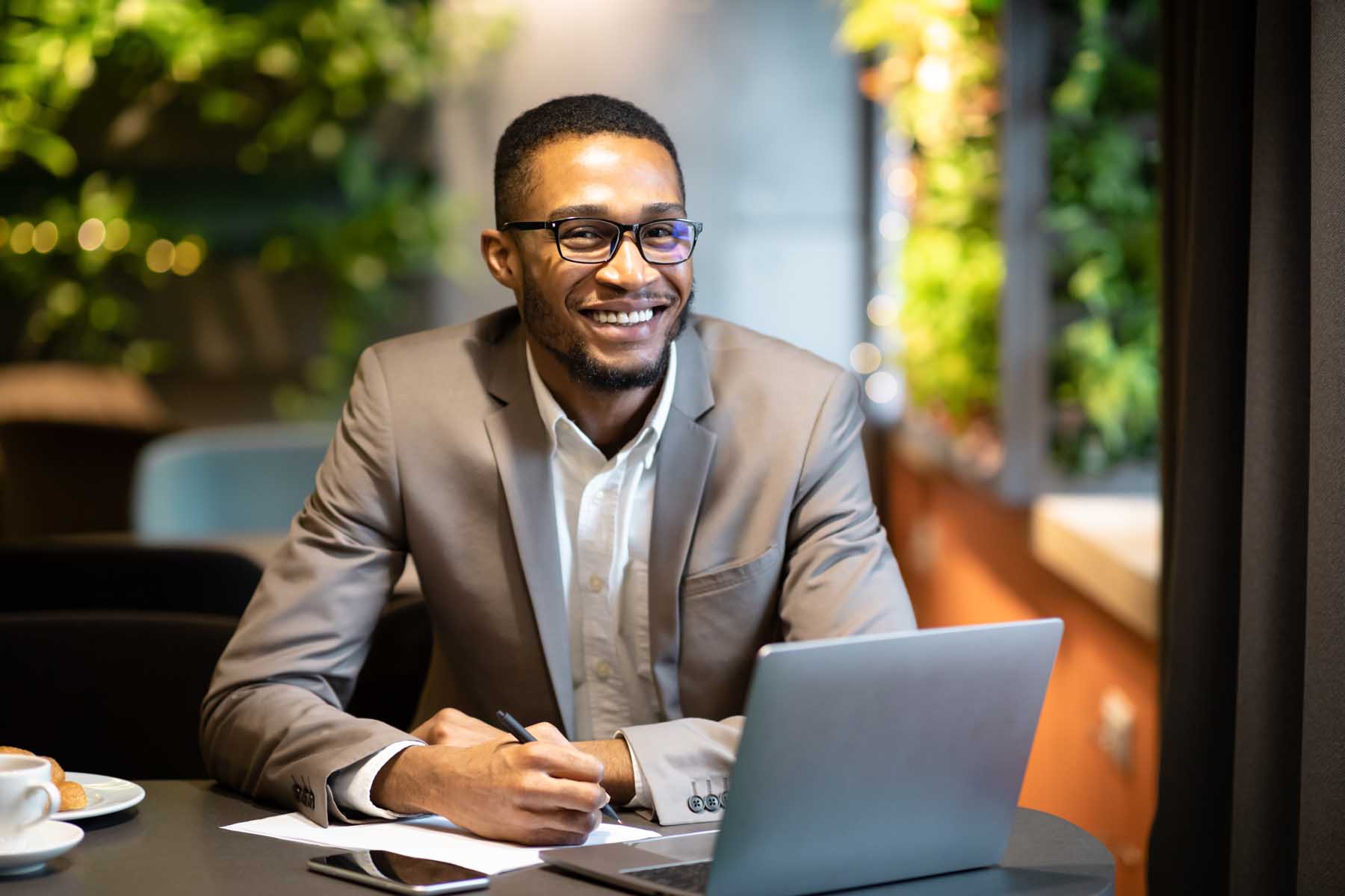 A young professional sits at a desk working on a laptop