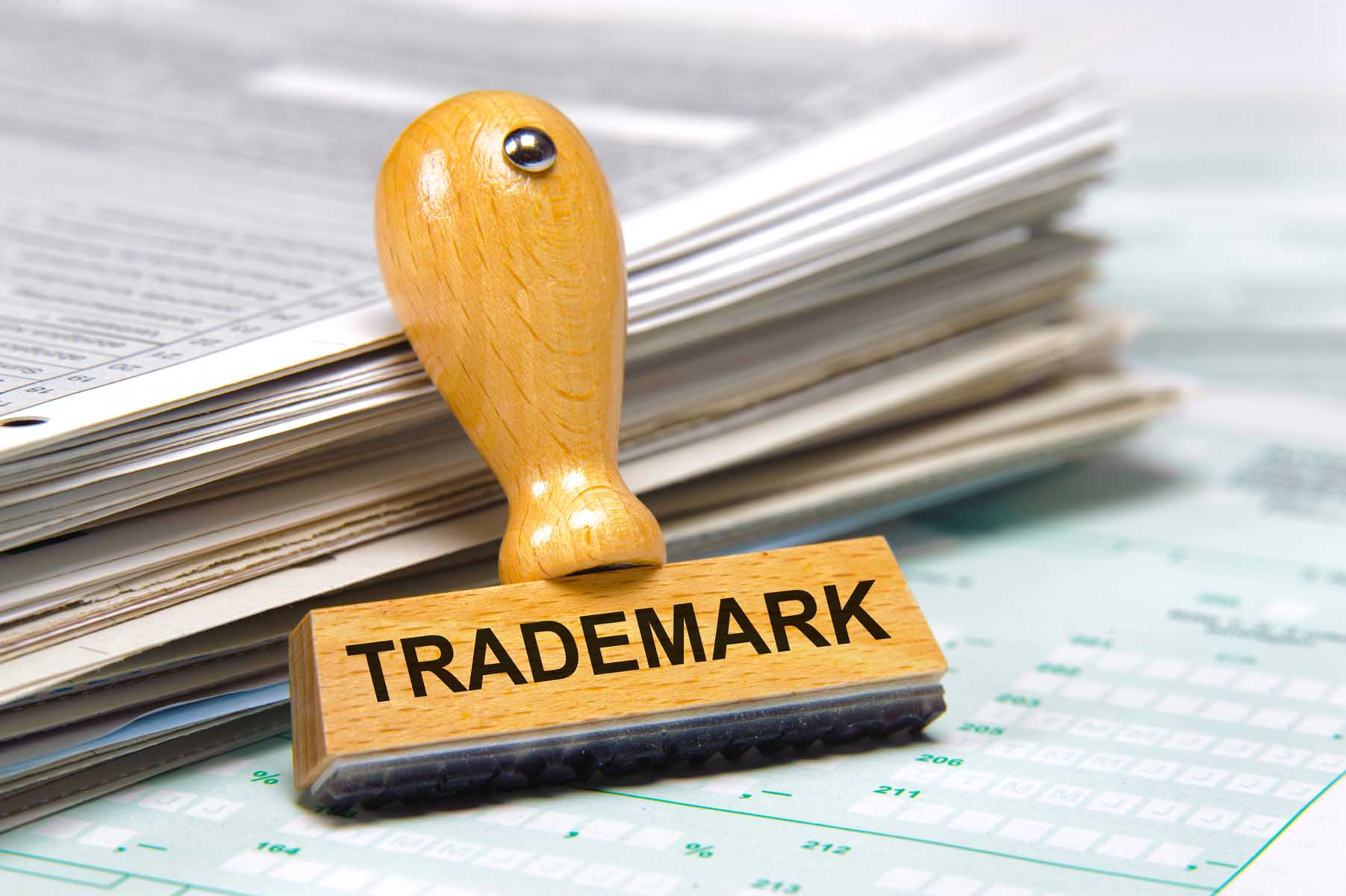 Trademark on rubber stamp with a stack of papers